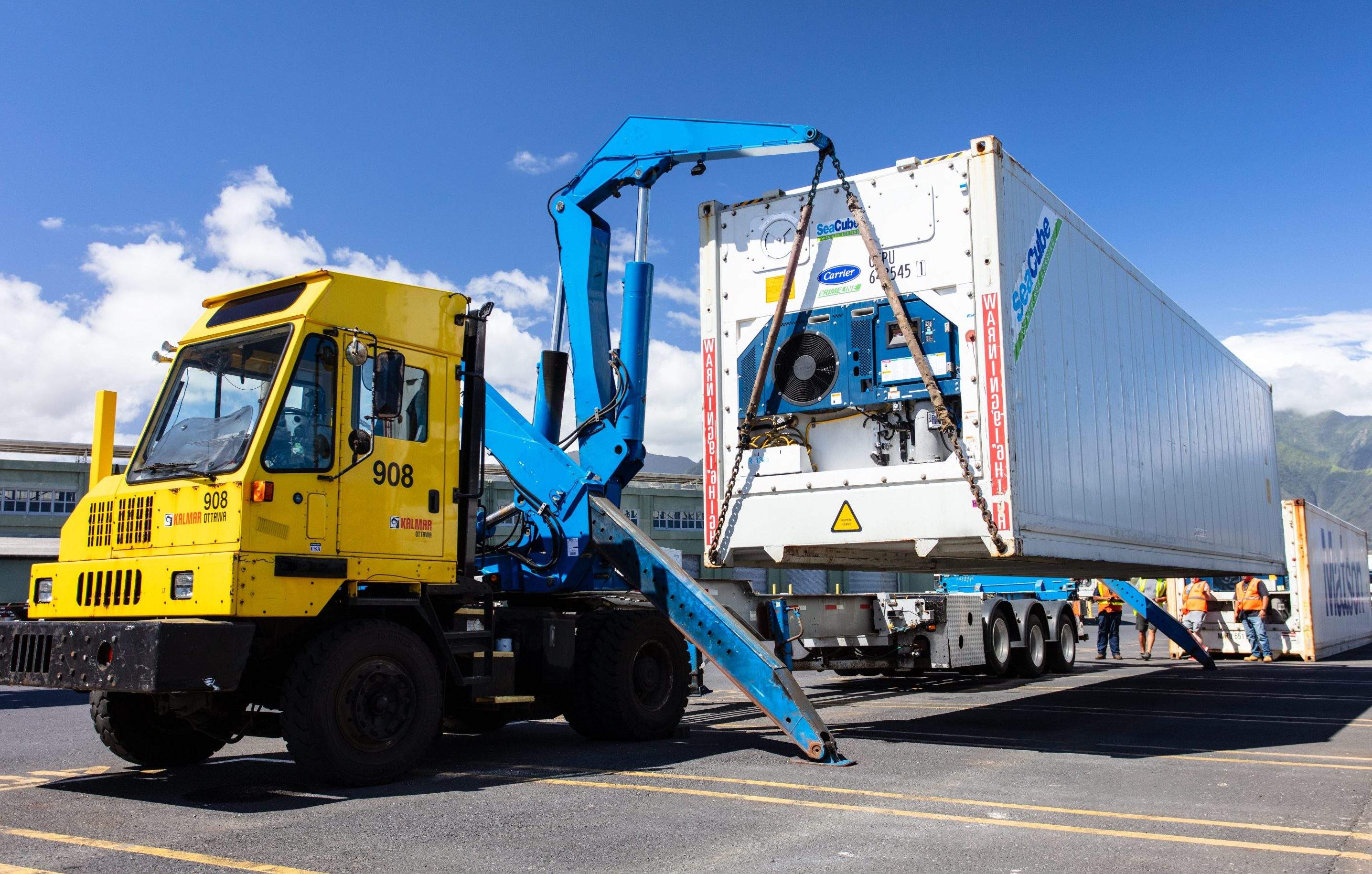 Sideloader delivers a refrigerated container to the ground at Kahului Terminal.
