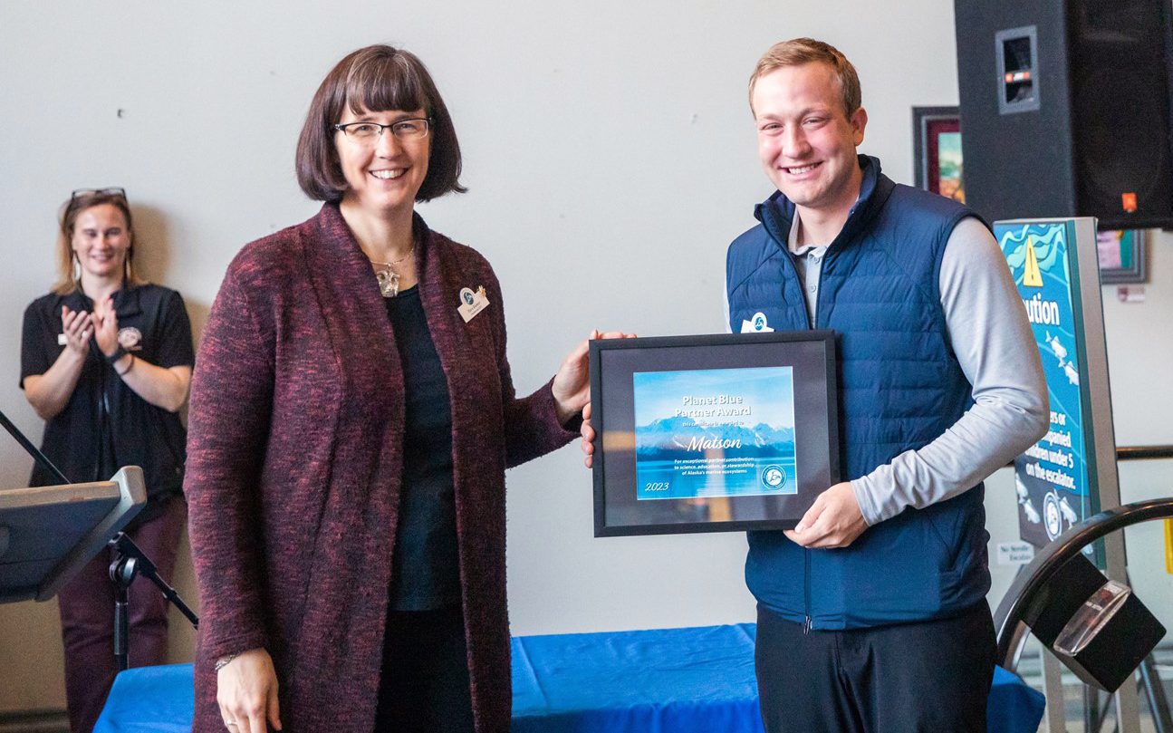 Dylan Faber holds the Blue Planet Partner Award plaque with Alaska Sea Life Center staff.