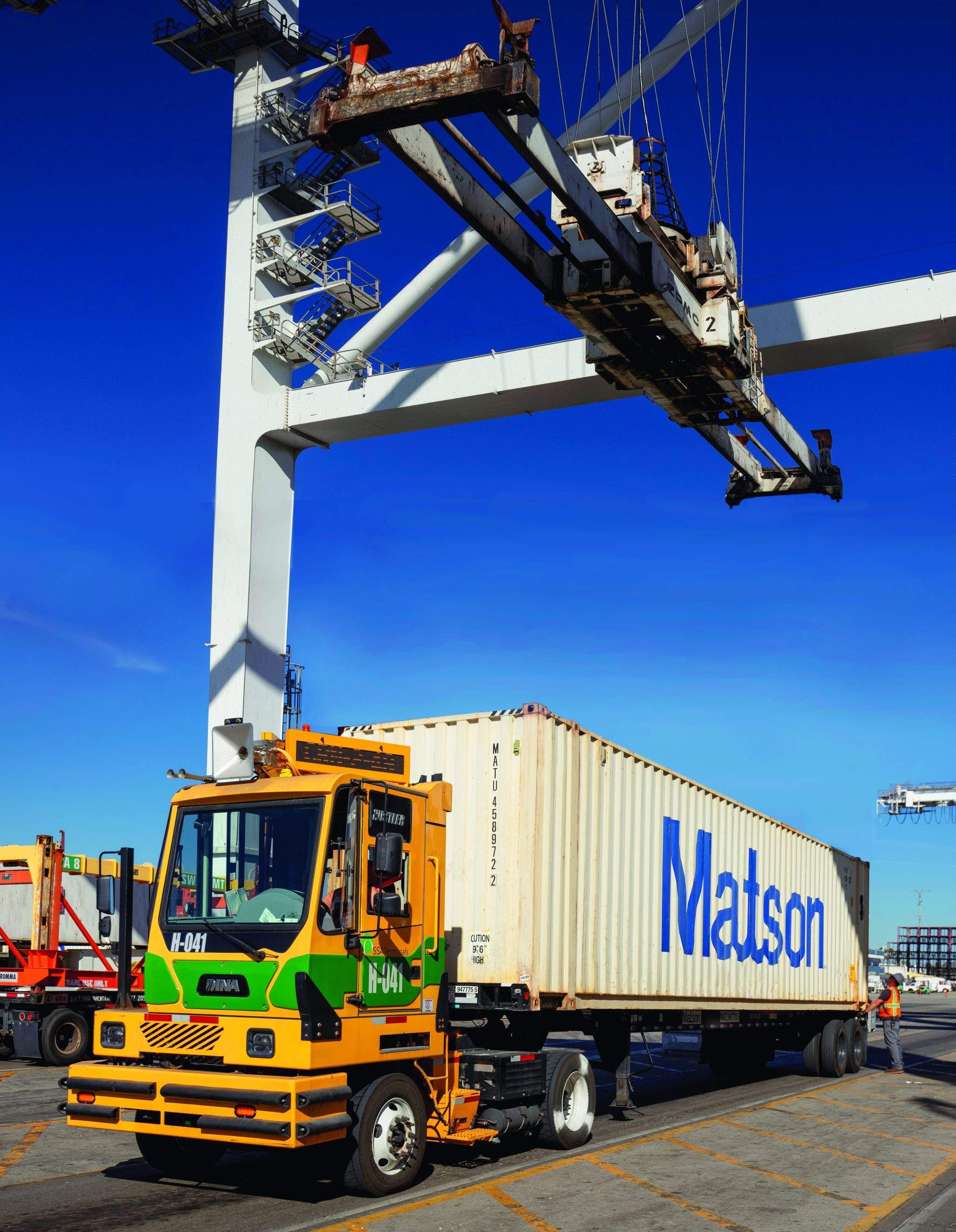 Zero-emission battery-electric yard tractor receives a Matson container to move around the Long Beach terminal.
